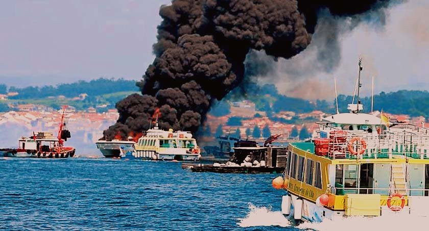 Labores de extinción del fuego en el catamarán que varó en A Toxa y la nube