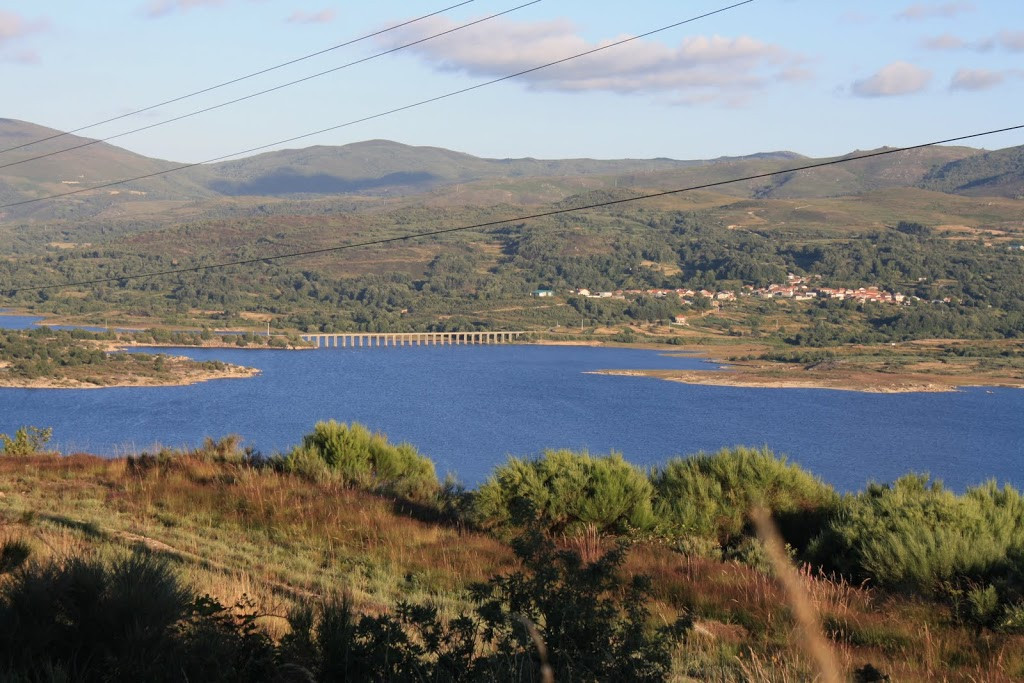 Aspecto de la coronación de la presa de Salas... con su kilómetro largo de longitud y con la Serra do Xurés al fondo.