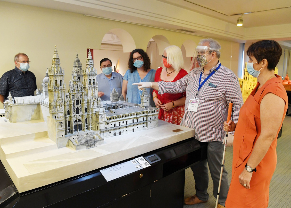 Un grupo de personas durante una viista guiada, junto a un voluntario del museo, ataviado con mascarilla, mu00e1scara y guantes 1500