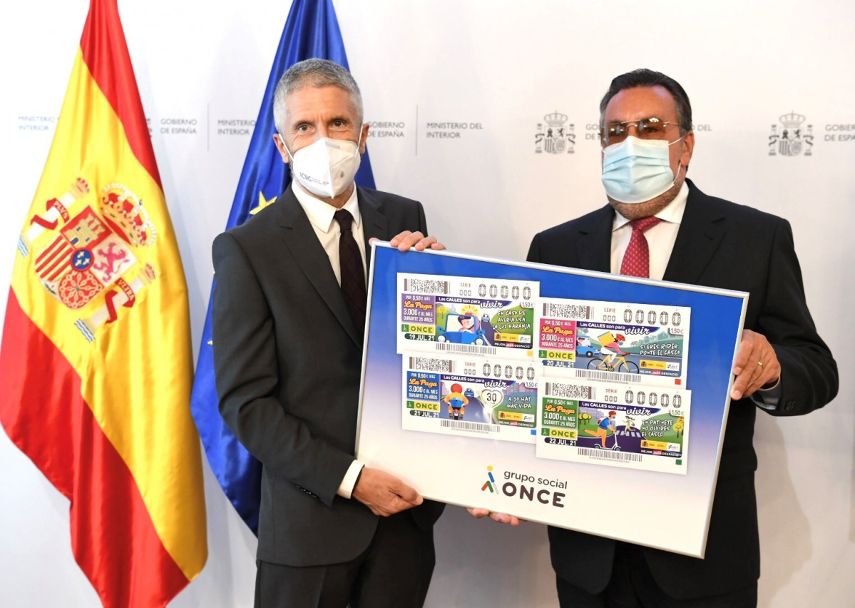 Fernando Grande Marlaska y Miguel Carballeda, con un cartel con las imágenes de los cupones 2