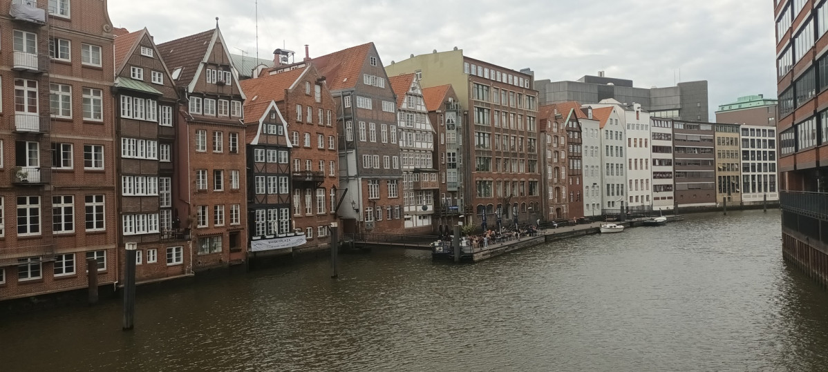 Vista de uno de los canales de Hamburgo, en primer plano una animada terraza sobre el agua