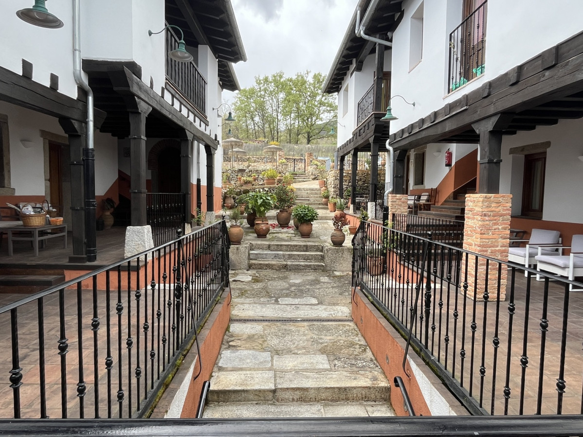 Zona ajardinada con habitaciones a ambos lados