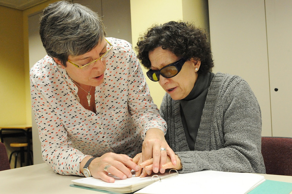 Una profesora de braille enseña a leer con las manos a una mujer ciega